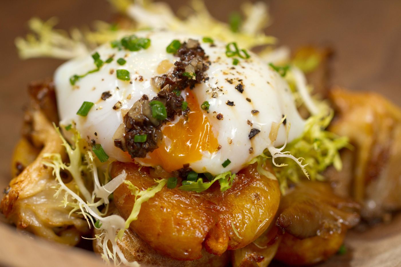 A plated dish of potatoes and a poached egg