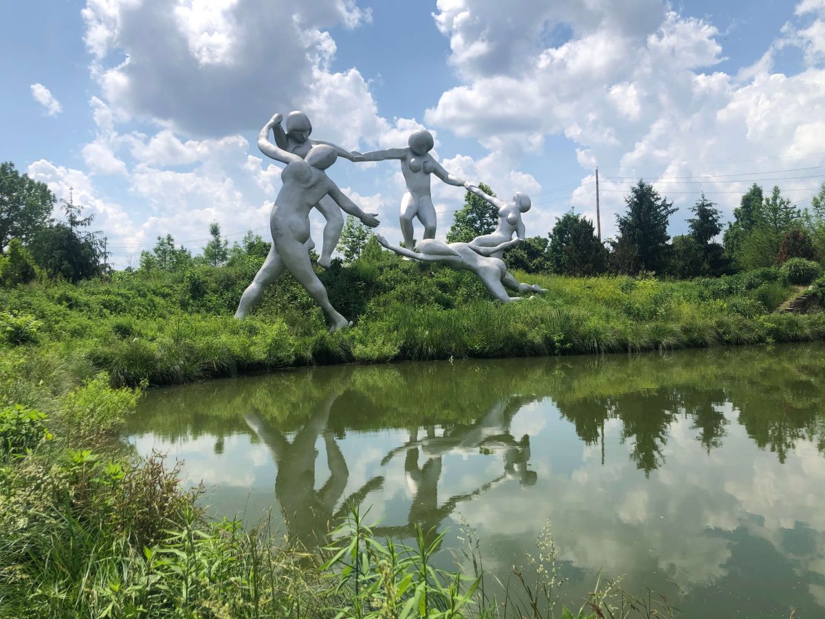 White dancing figures on the bank of still water