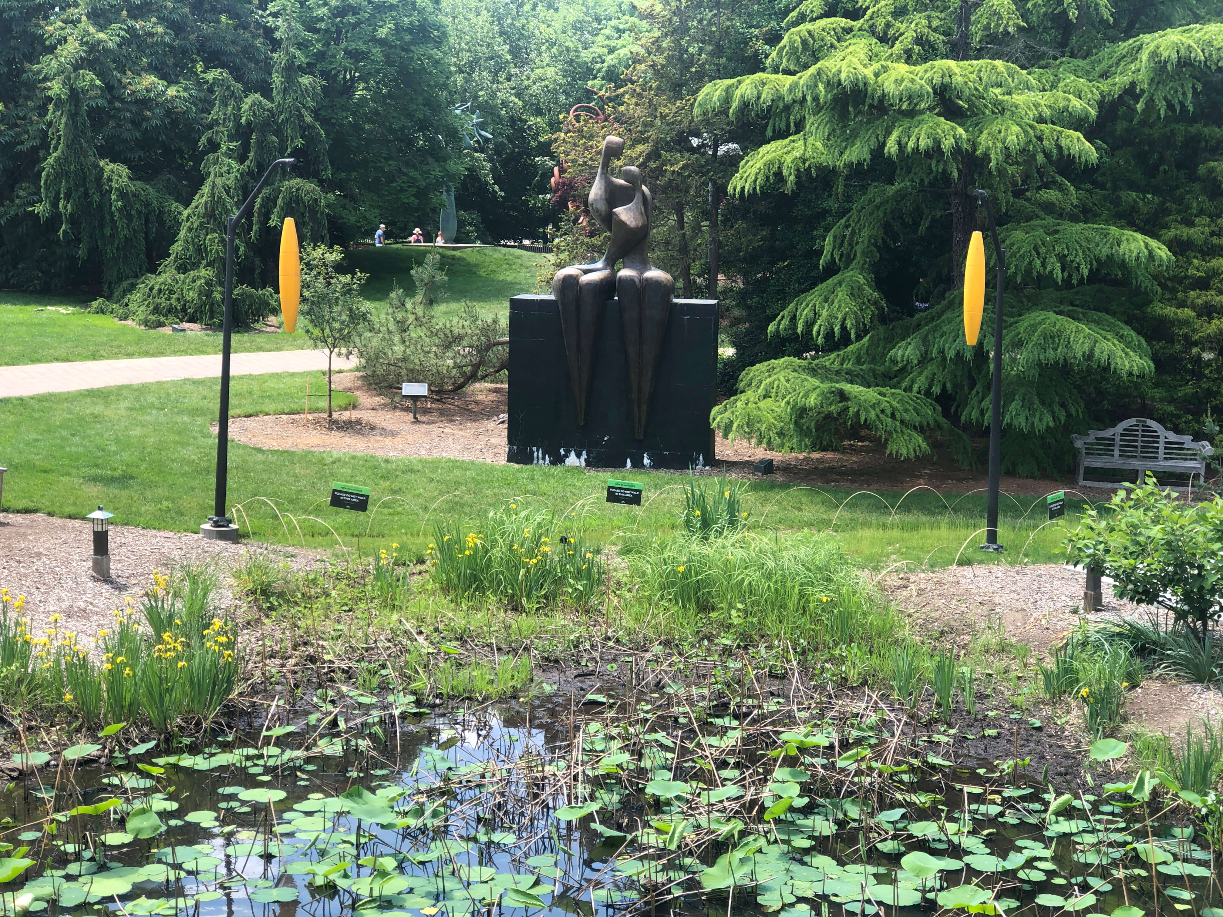 A bronze figure sculpture above a lily pond